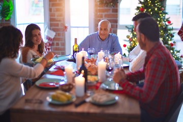 Beautiful family smiling happy and confident. Eating roasted turkey celebrating Christmas at home