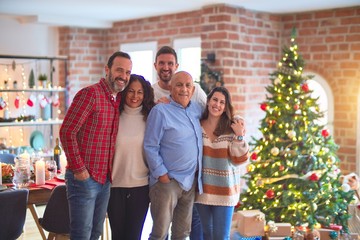 Beautiful family smiling happy and confident. Standing and posing with tree celebrating Christmas at home