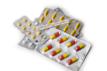 a traditional glass mercury thermometer, tablets and capsules with medicine around