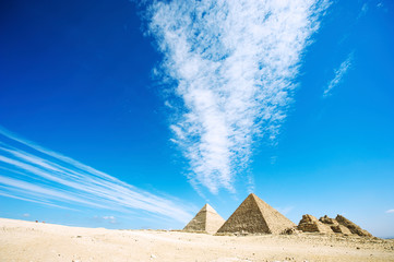 Fototapeta na wymiar Dramatic cloudscape pointing toward the crumbling Giza pyramid complex in the desert plateau outside Cairo, Egypt