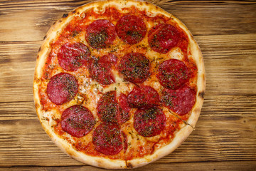 Delicious fresh pizza with sausage and cheese on a wooden table. Top view