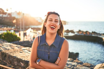 Beautiful young woman walking on beach promenade enjoying ocean view smiling happy on summer vacation