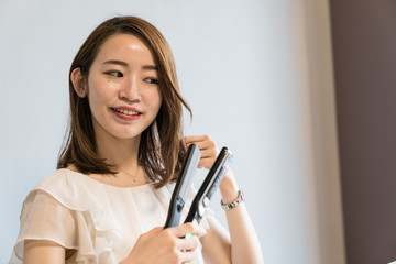 ヘアアイロンを使う女性