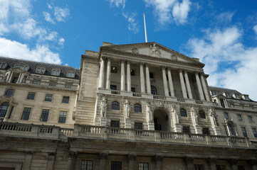 Sunny view of the facade of the Bank of England building in the historic financial center under bright blue sky in the City of London, UK