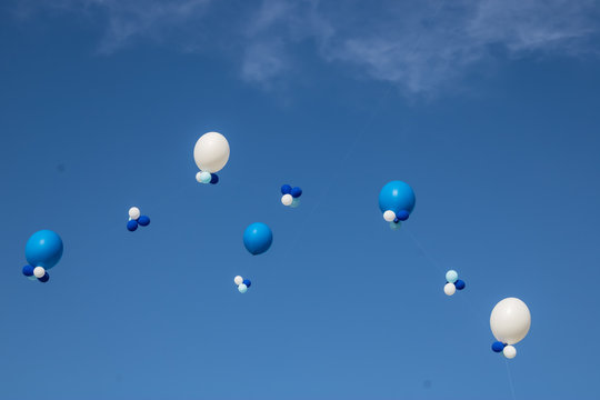 Balloons on the blue sky background with clounds, blue and white helium balloons in the air, event decoration with balloons - Image