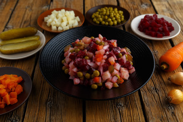 Traditional Russian dish vinaigrette. Vegetarian salad of beets, potatoes, carrots, pickles, green peas and onions. Healthy eating concept.