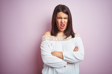 Obraz premium Young beautiful brunette woman over pink isolated background skeptic and nervous, disapproving expression on face with crossed arms. Negative person.