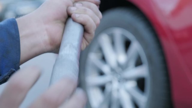 Mechanic using a torque wrench socket and extension on the lug nuts of a truck wheel.