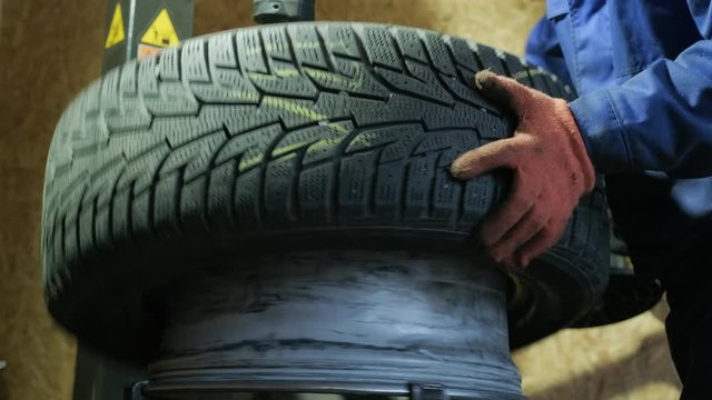 Change a tyre, Car mechanic is changing a tyre in a garage