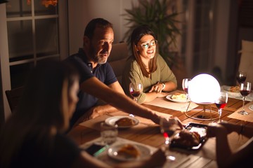Beautiful family on dinner talking and smiling at terrace