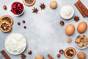 Fototapeta na wymiar Ingredients for baking cookies, cupcakes and cake. Frame of Raw foods eggs flour sugar cottage cheese cranberries on a grey background with copy space.