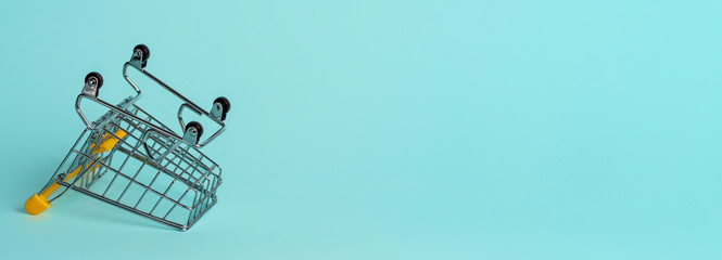 Empty inverted shopping cart on blue background. Inverted toy trolley on bright blue background, copy space for text or design. © fascinadora