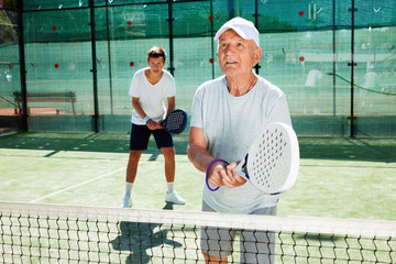 padel players of different generations playing padel court
