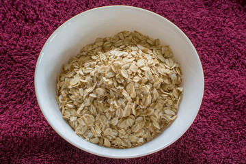 Oatmeal flakes on a ceramic plate. Oatmeal is porridge made from oatmeal, crushed or not crushed, rolled, oatmeal or oat flakes