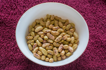 White beans on a ceramic plate, seeds of annual garden bean plant with long narrow fruits