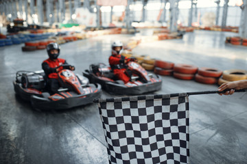 Two kart racers on start line, checkered flag - obrazy, fototapety, plakaty