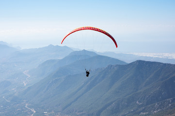 Paraglider flying over mountains