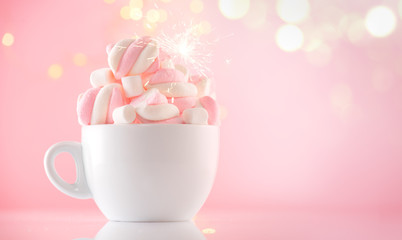 Marshmallow. Close-up of Marshmallows colorful chewy candy, over pink bokeh background, closeup. Sweet holiday food dessert in a cup with hot chocolate close-up. Candies