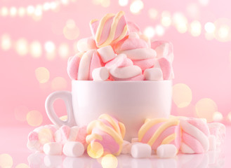 Marshmallow. Close-up of Marshmallows colorful chewy candy, over pink bokeh background, closeup. Sweet holiday food dessert in a cup with hot chocolate close-up. Candies