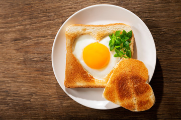 Valentines day.  Breakfast with fried egg and toasted bread shapped heart, top view