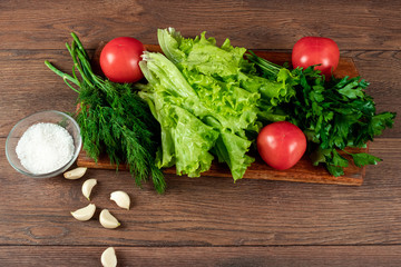 Ingredients for making salad, fresh vegetables on a wooden background.