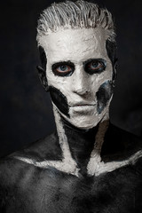 Portrait of a guy in dark makeup with a skull pattern. Halloween mask