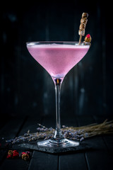 Purple cocktail alcoholic with cream on a dark wooden background