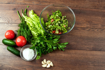 Ingredients for making salad, fresh vegetables on a wooden background.