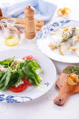 summer light lunch. Salad with spinach, cheese and tomato. Salad with pear and cheese. Salads are decorated on white plates