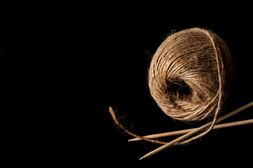 yarn and wooden knitting needles on a black background