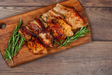Pork steak and sprig of rosemary on a wooden cutting board. Recipe, cooking meat.