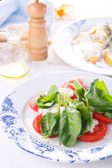 summer light lunch. Salad with spinach, cheese and tomato. Salad with pear and cheese. Salads are decorated on white plates