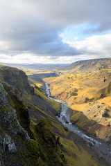 Tourist takes photo on mobile phone of second highest waterfall in Iceland - Haifoss. Picturesque sunrise view of deep canyon. Travel to Iceland. Beauty of nature concept background..