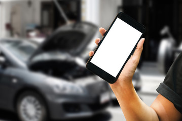 Hand holding blank screen smartphone and blurred car accident in background.