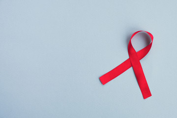 Red ribbon awareness Aids on a light blue background. Medicine concept, World Aids day campaign....