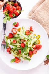 light summer detox salad with strawberries, cucumber, nuts and flax seeds