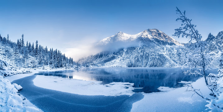 Winter panoramic landscape with scenic frozen mountain lake