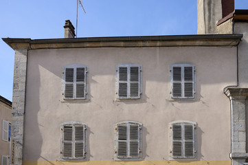 Typical facade of an old apartment above shops in the Frence town of Poligny in the Jura department in Franche-Comté.