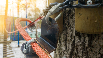 Close up of red rope and metal clips used for suspension bridge to the rope Park