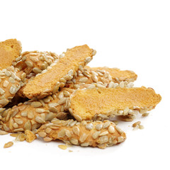 A broken breadstick with sunflower seeds and crumbs on white background