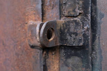 A close up shot of an old rusted key on a metal door keyhole.