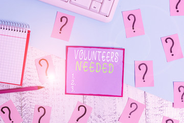 Handwriting text Volunteers Needed. Conceptual photo need work or help for organization without being paid Writing tools, computer stuff and math book sheet on top of wooden table