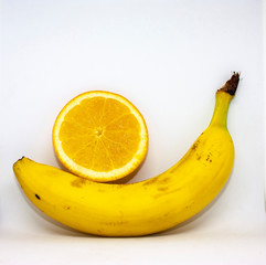 Fresh organic orange and banana close-up on a white background with place for text.