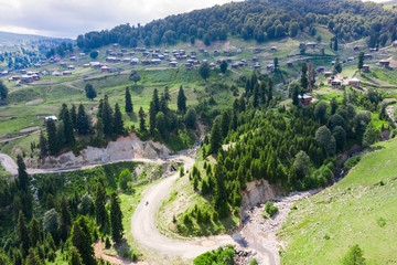 Fototapeta na wymiar Beautiful nature with country cottages and traditional wooden houses on the road through the Goderdzi Pass in Georgia.