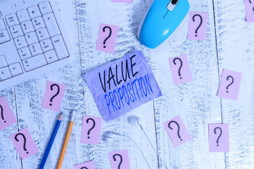 Writing note showing Value Proposition. Business concept for feature intended to make a company or product attractive Writing tools and scribbled paper on top of the wooden table