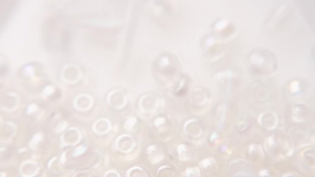 Pouring a white transparent bead bag in a store.
