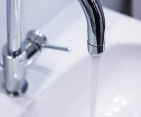 Saving water: Close up of spigot with clear, flowing water