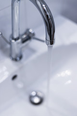 Saving water: Close up of spigot with clear, flowing water