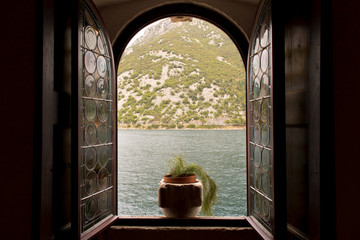 Open window with sea and mountain views.
