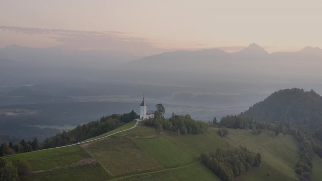 Sunrise over Jamnik, Slovenia. Aerial drone view over Alps and Church St. Primoz